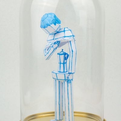 Figura de papel dentro de redoma de vidro com base dourada