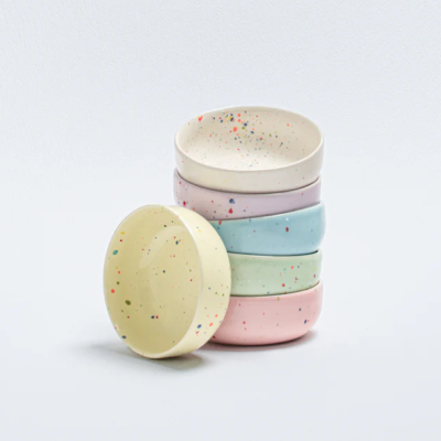 Cinco tigelas coloridas empilhadas com padrão salpicado