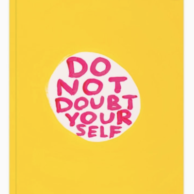 Caderno amarelo A5 com frase motivacional em vermelho