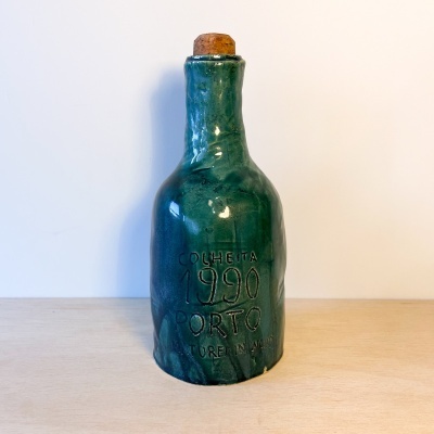 Garrafa de cerâmica verde com tampa de cortiça e texto gravado