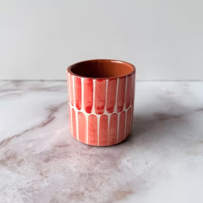 Vaso de cerâmica vermelho com padrão de linhas verticais