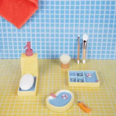 Conjunto de acessórios de casa de banho amarelo com sabonete e pincéis em azulejos azuis e amarelos