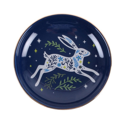 Prato de cerâmica azul com desenho de coelho branco decorado com flores e folhas.