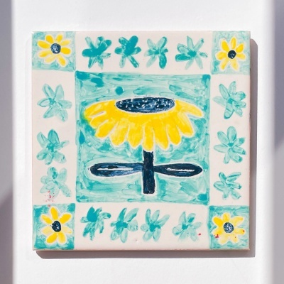 Azulejo cerâmico pintado à mão com girassol amarelo e padrões florais em azul e verde água