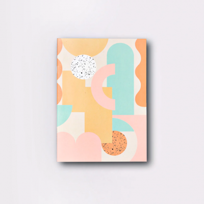 Caderno com capa colorida geométrica e padrões pontilhados em fundo cinza