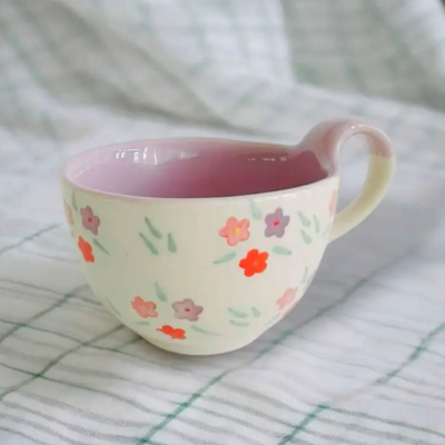 Chávena de cerâmica creme com flores coloridas e interior rosa