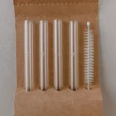 Quatro palhinhas de vidro transparentes com escova de limpeza em suporte de cartão