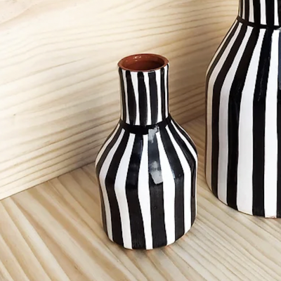 Vasos de cerâmica listrados a preto e branco sobre superfície de madeira