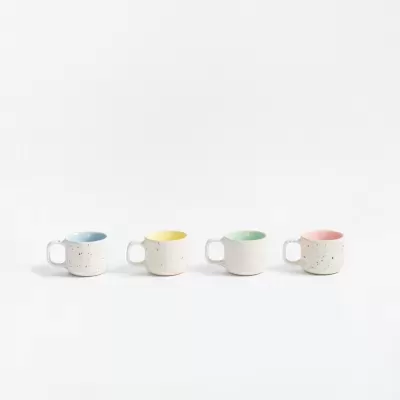 Quatro canecas de cerâmica com interior colorido e exterior branco pontilhado