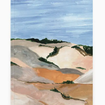 Livro com capa ilustrada de dunas de areia e céu azul.