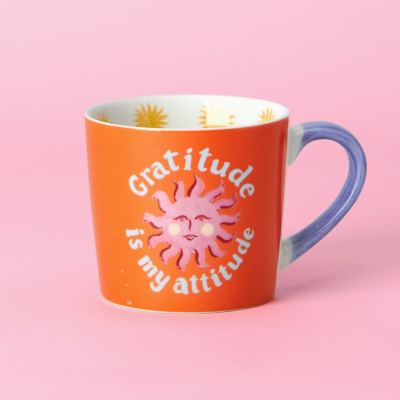 Caneca laranja com texto e sol rosado e asa azul