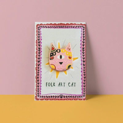 Pin em forma de gato com design de arte popular sobre cartão com texto FOLK ART CAT