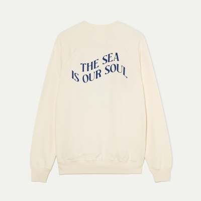 Sweatshirt creme com texto azul THE SEA IS OUR SOUL no verso