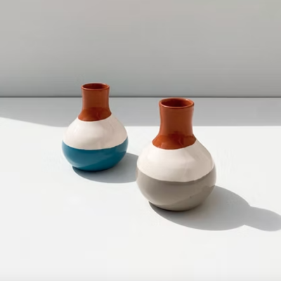 Dois vasos cerâmicos tricolores em branco, castanho, azul e cinza sobre superfície branca