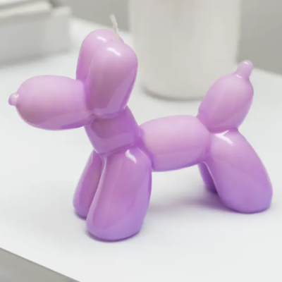 Vela em forma de cão balão lilás sobre superfície branca