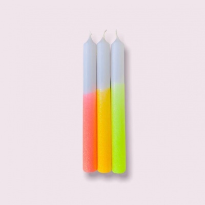 Três velas coloridas com topo branco e base fluorescente