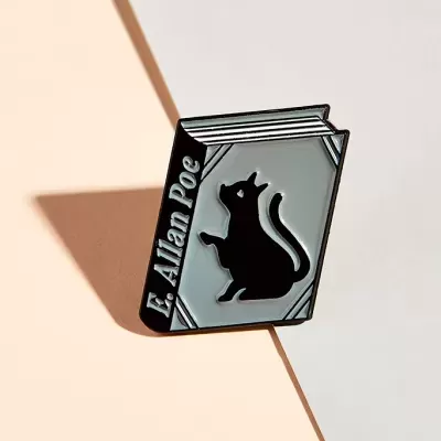 Pin metálico em forma de livro com gato e texto 'E. Allan Poe'