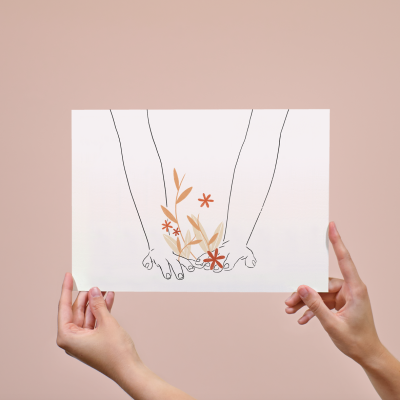 Papel branco com ilustração minimalista de mãos e flores em tons castanhos e laranja, segurado por duas mãos.