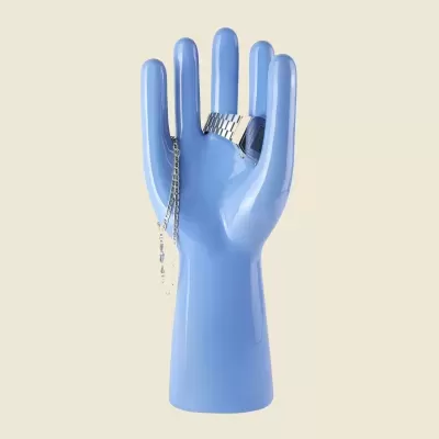 Expositor de mão azul com joias prateadas