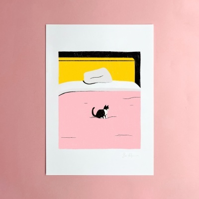 Ilustração de uma cama com colcha rosa, almofada branca, cabeceira amarela e preto, com gato preto e branco sentado