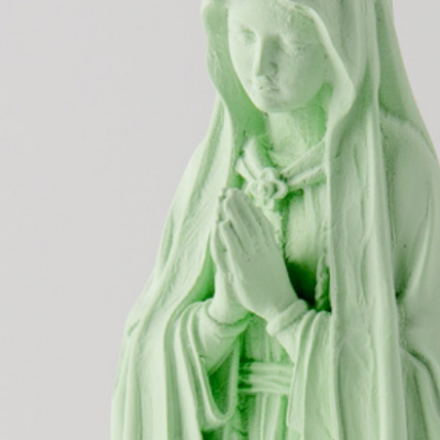 Estátua verde claro de figura feminina de manto e mãos unidas
