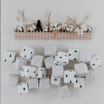 Calendário do advento em madeira com pequenos sacos brancos decorados suspensos