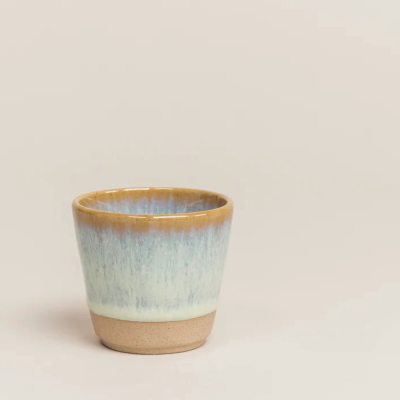 Vaso cerâmico vidrado em tons castanhos, azul e bege com base natural.