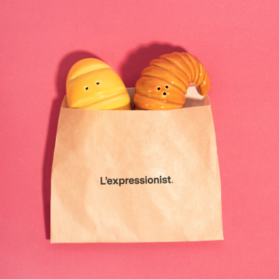Conjunto de saleiros em forma de pastelaria numa bolsa de papel com texto L’expressionist