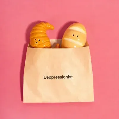 Sal e pimenta em cerâmica em forma de croissant e pão em saco de papel castanho