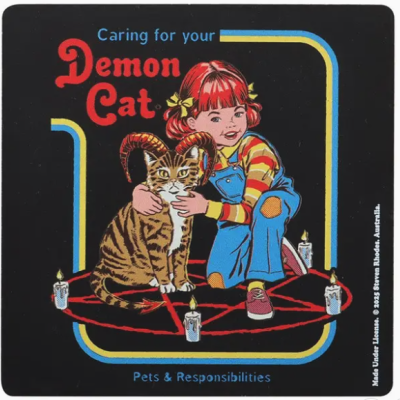 Menina ruiva abraçando gato com chifres num pentagrama vermelho com velas acesas