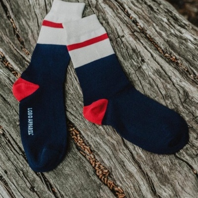 Par de meias coloridas azul, branco e vermelho sobre madeira envelhecida