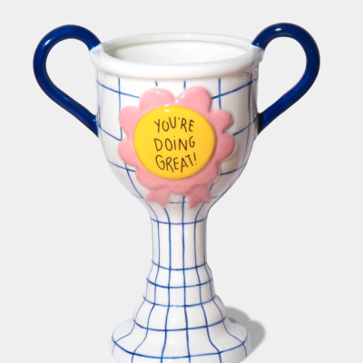 Taça cerâmica branca com linhas azuis, punhos azuis e flor rosa com texto amarelo