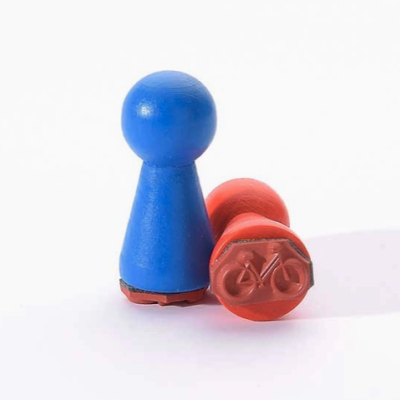 Dois peões de madeira azul e vermelho com detalhe de bicicleta na base do peão vermelho