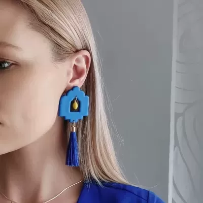 Brinco azul pendente com tassel azul e detalhe amarelo no centro