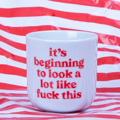 Caneca branca com texto vermelho e fundo riscado vermelho e branco