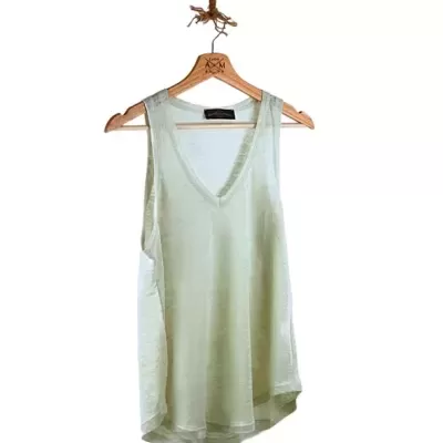 Blusa creme leve pendurada num cabide de madeira suspenso