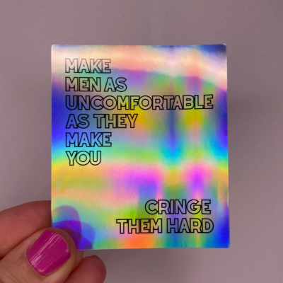 Cartão holográfico com texto em letras maiúsculas pretas e mão segurando com unha rosa