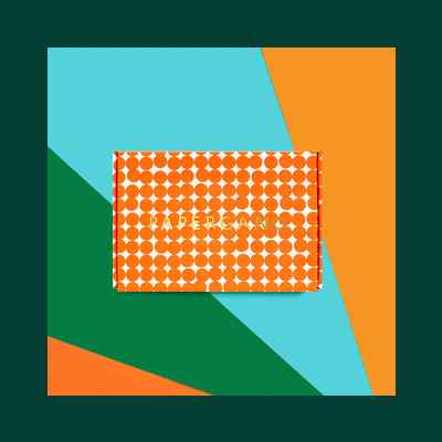 Caixa retangular com padrão de bolas laranja e branco e texto dourado PAPER DREAMS sobre fundo colorido