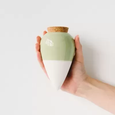 Vaso cerâmico verde e branco com tampa de cortiça
