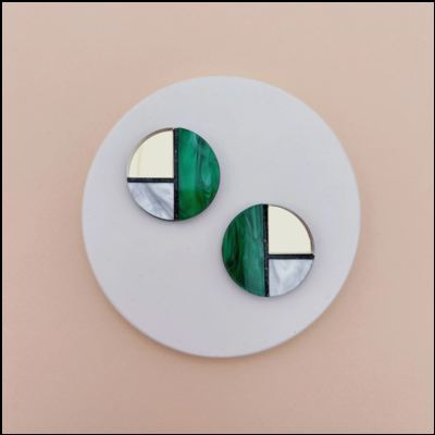 Brincos redondos verde, branco e dourado sobre disco branco