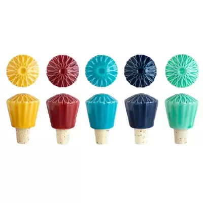 Cinco rolhas de garrafa coloridas com padrão em relevo dispostas em fila sobre fundo branco