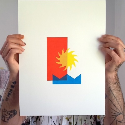 Papel branco com arte abstrata colorida segurado por pessoa com tatuagens