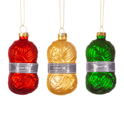 Ornamentos de Natal em forma de novelos de lã nas cores vermelho, dourado e verde com etiqueta Durable