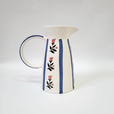 Jarro de cerâmica branca com riscas azuis e flores cor-de-rosa, fundo branco