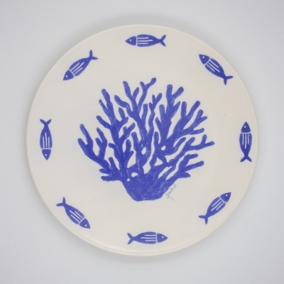 Prato de cerâmica branco com desenho azul de coral e peixes.