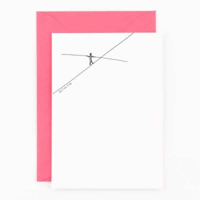 Cartão branco com desenho de artista na corda bamba e envelope vermelho