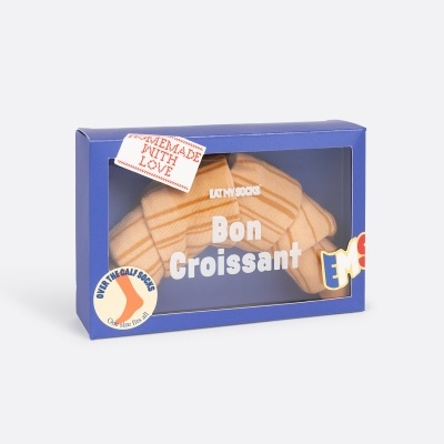 Embalagem azul com produto em formato de croissant e textos promocionais.