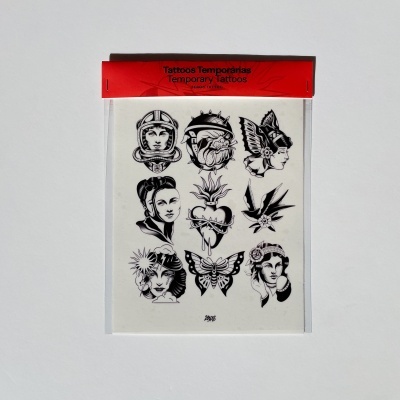 Pacote de tatuagens temporárias com vários desenhos a preto e branco em fundo branco e embalagem vermelha.