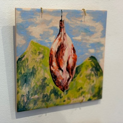 Quadro pintado com carne pendurada e fundo de montanhas verdes e céu azul
