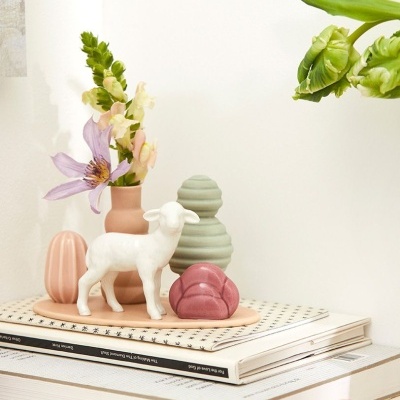 Conjunto decorativo em cerâmica com ovelha branca, vasos coloridos, flores e livros empilhados